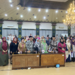 Group of people in traditional attire posing together in a banquet hall for a formal event.