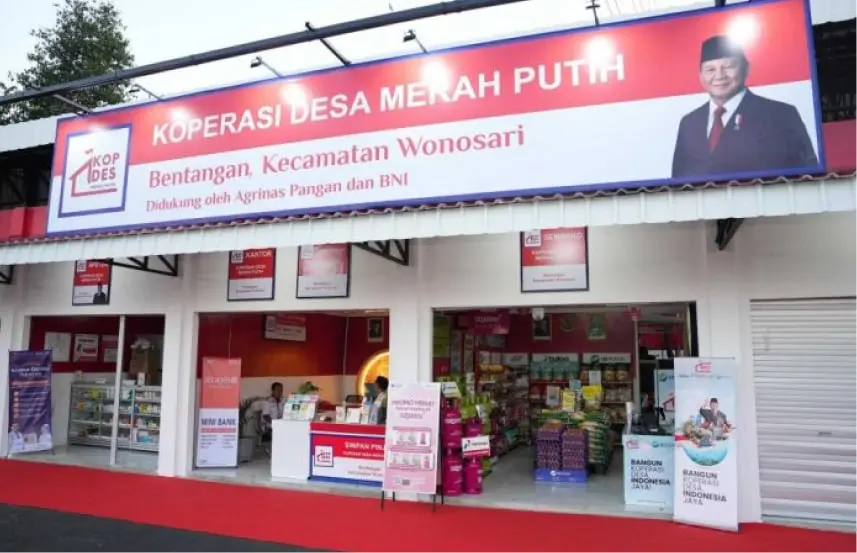 Front view of Koperasi Desa Merah Putih store with a red sign, open entrance, and customers shopping inside.