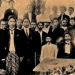 Historic group portrait of Black men and women in formal dress gathered around a coffin with a floral arrangement at a funeral.