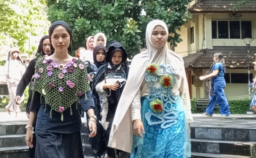 Group of women wearing hijabs and colorful traditional outfits walking down steps outdoors; a building is in view behind them.